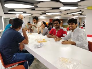 Attendees eating lunch together at a long table during a PyDelhi meetup