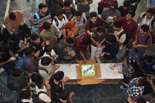 Attendees clapping around a Django cake